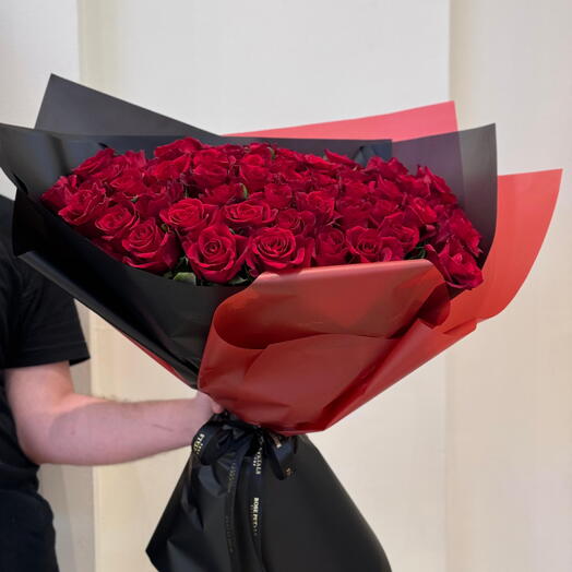 Bouquet de roses rouges avec un emballage noir et rouge