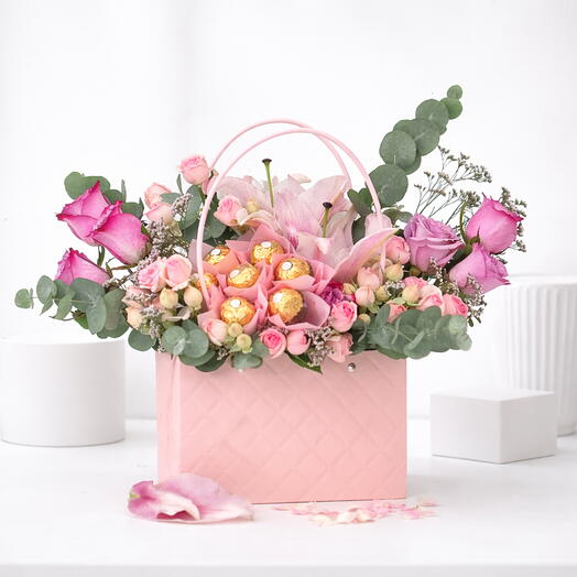 Pastel pink floral arrangement with chocolates
