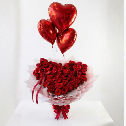 99 красных роз в розовой упаковке с 3 красными гелиевыми шарами в форме сердца