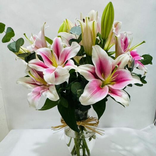 Розовые лилии в стеклянной вазе;