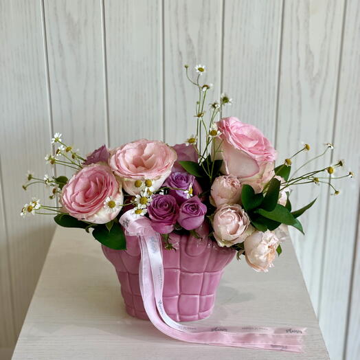 Свежие цветы в розовой керамической сумочке