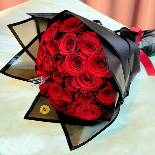 Букет красных роз. Букет свежих красных роз, связанный вручную в черной упаковке.
