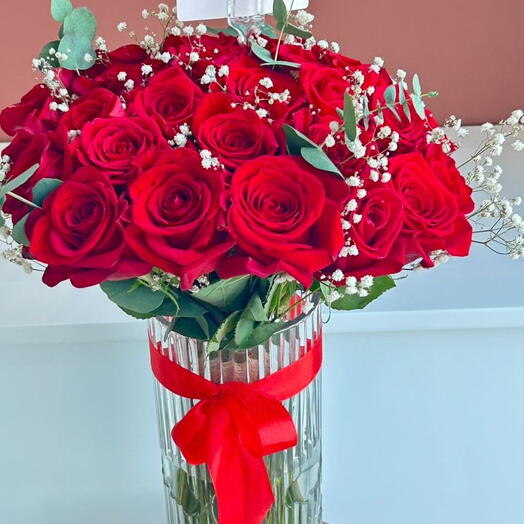 وردة حمراء فاخرة في مزهرية زجاجية