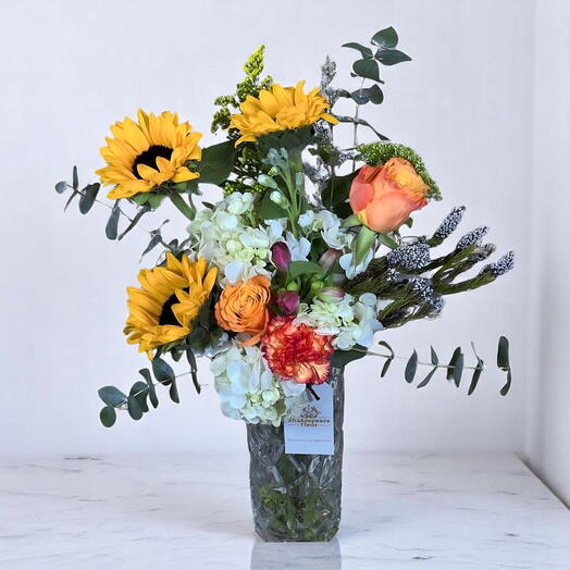 Букет Crystal Elegance с подсолнухами, гортензиями   оранжевыми розами в премиальной стеклянной вазе