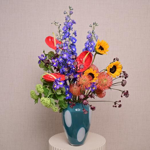 Смесь ярких цветов в синей стеклянной вазе в горошек  7223