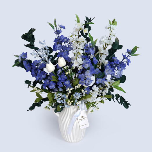 Ваза с искусственной синей и белой цветочной композицией