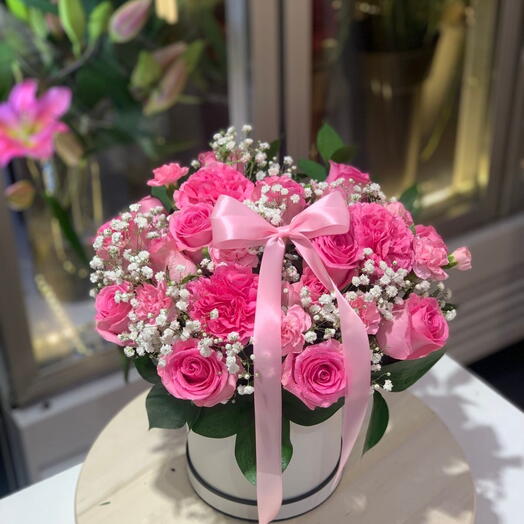 Flores rosas en una caja con lazo rosa