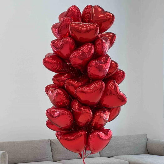 Cloud of 50 red foil heart balloons