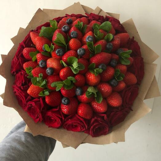 Bouquet of red roses with fresh strawberries in the middle