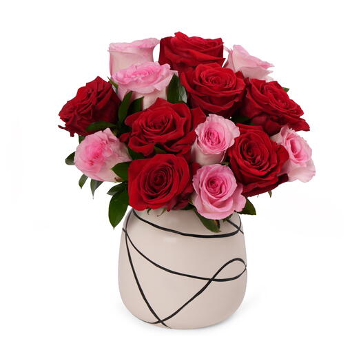 Розовые и красные розы в дизайнерской вазе