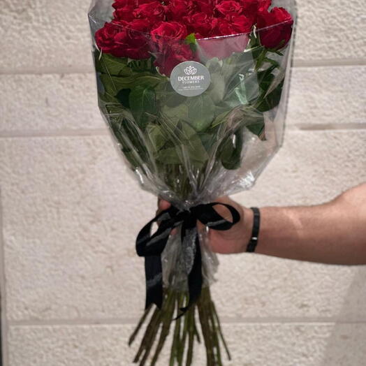 Red roses bouquet wrapped in a transparent plastic