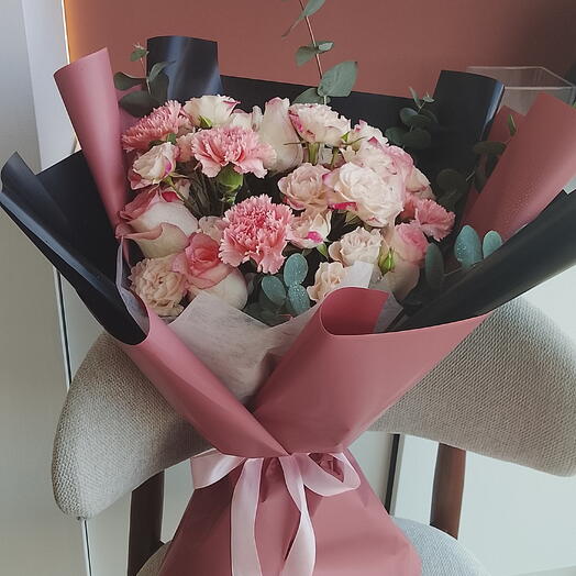 باقة ورد أنيقة باللونين الوردي والأبيض مع لمسات من الأوكالبتوس