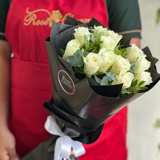 Букет «Чистая грация» | 12 белых роз с наполнителями, упакованных в элегантную коричневую упаковку.